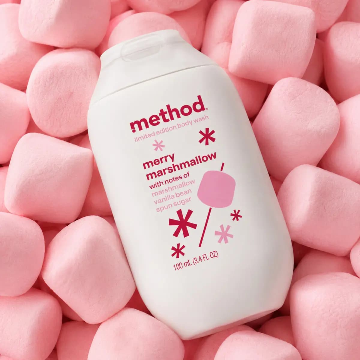 Merry Marshmallow body wash bottle resting on a pile of soft pink marshmallows