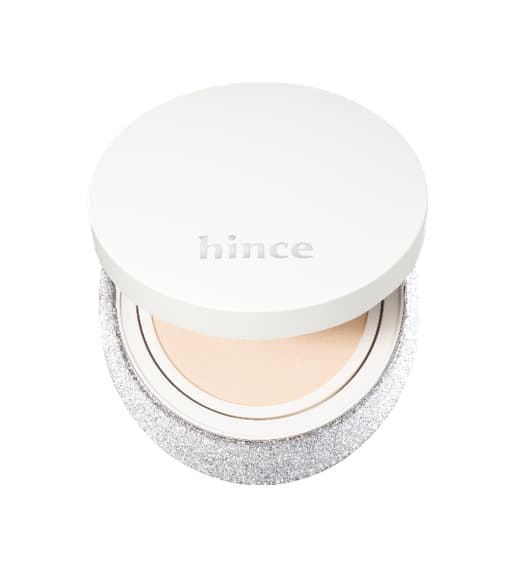 Open white hince cushion compact with sparkling silver glitter base revealing a light beige cushion pad