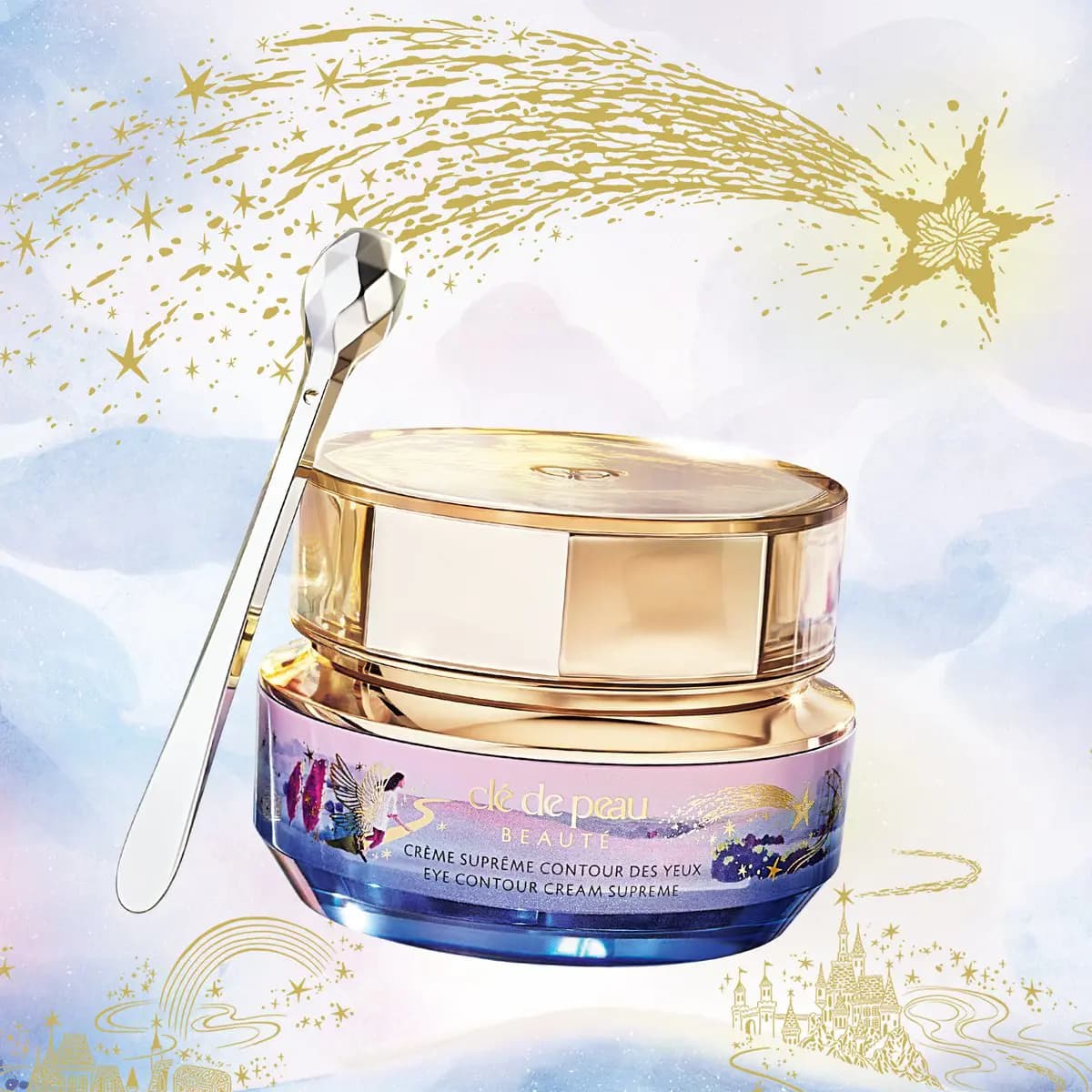 Clé de Peau Beauté Eye Contour Cream Supreme jar with gold lid and silver spatula under a gold shooting star