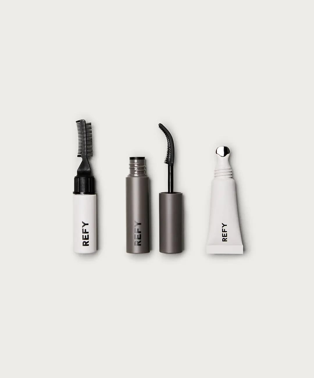 Mini brow gel with comb wand, open grey mascara with curved brush, and white lip gloss tube with metal tip