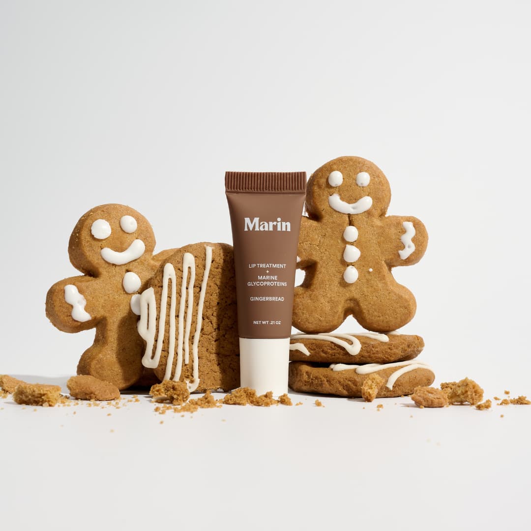 Brown Gingerbread tube between iced gingerbread men and drizzled cookies with crumbs