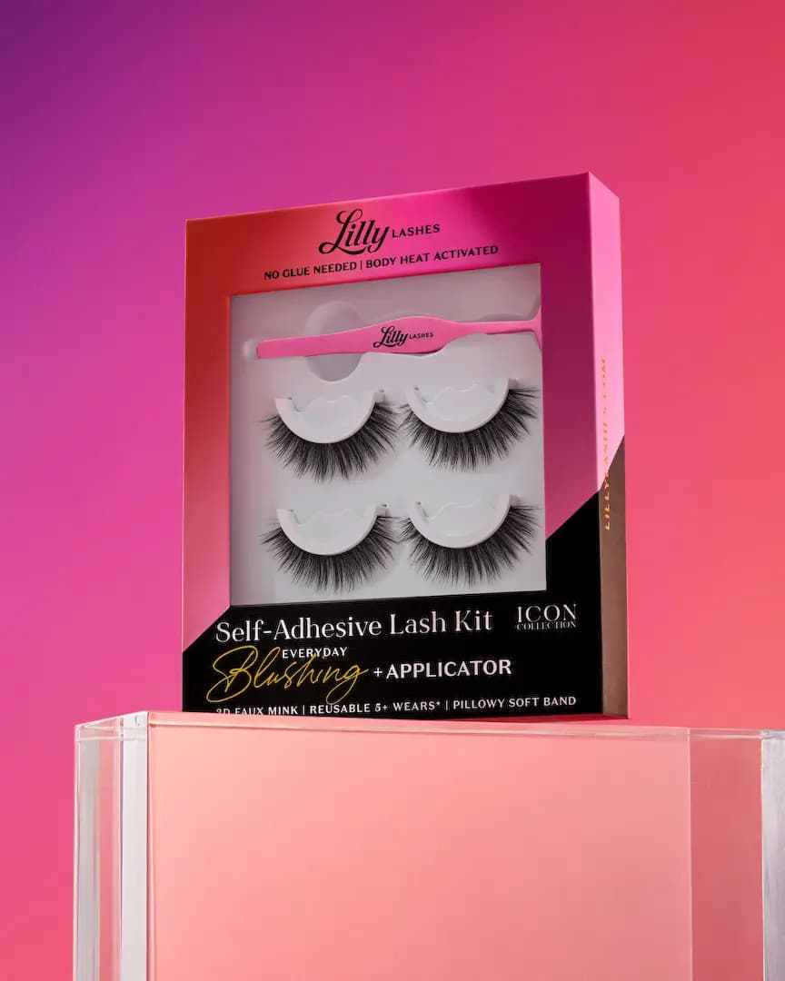 Lilly Lashes Blushing kit box angled on a clear acrylic block against a purple-to-coral gradient backdrop