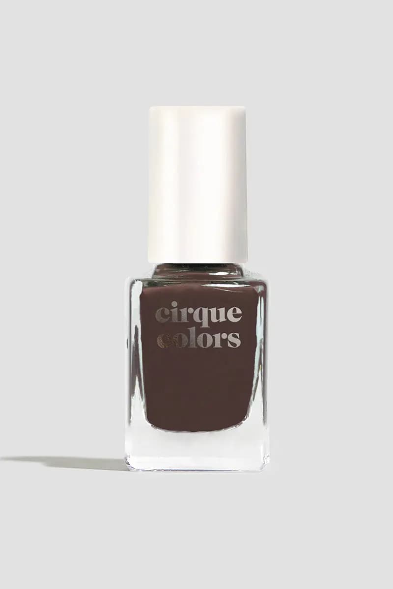 Single bottle of deep chocolate brown polish with a white cap on a grey background