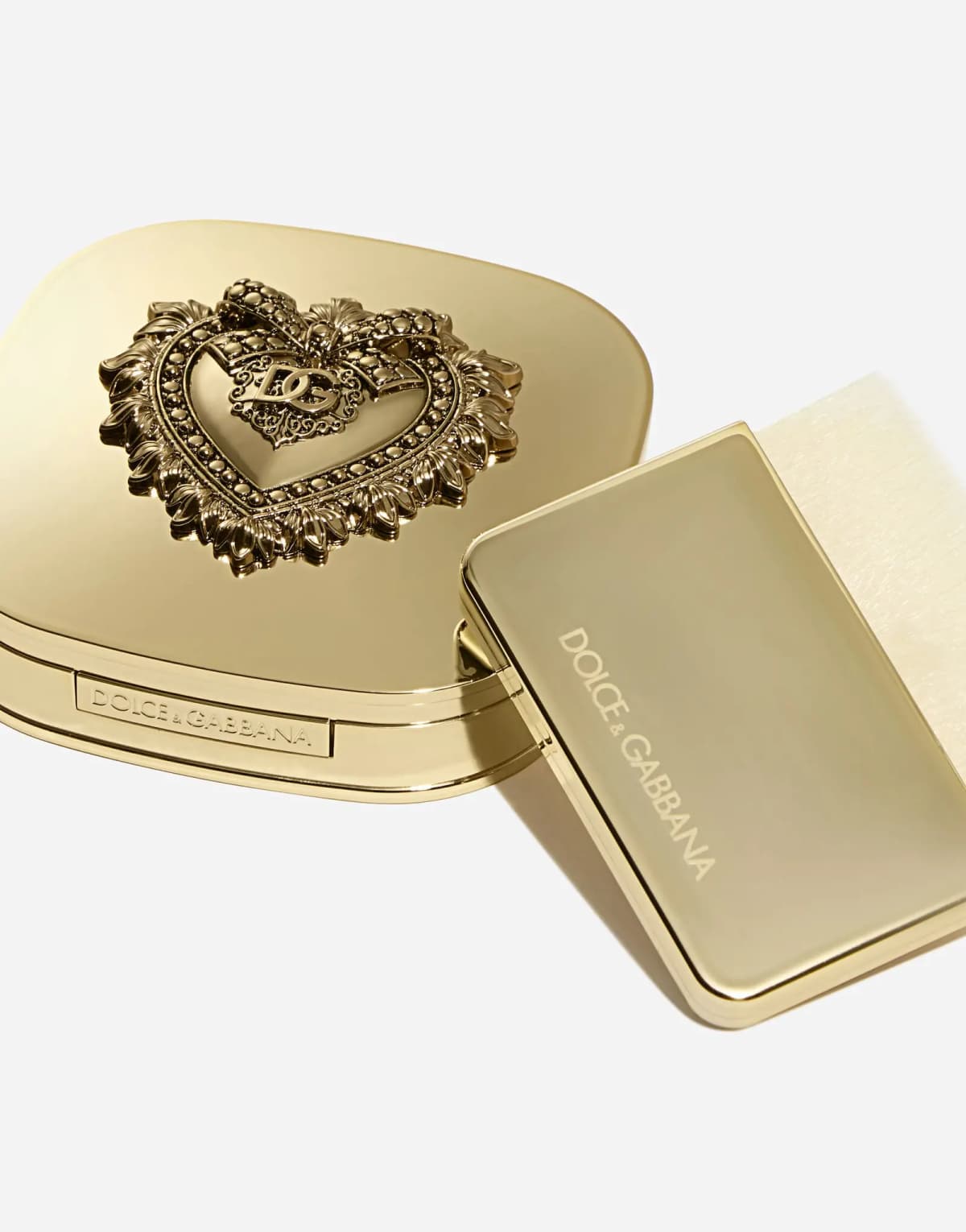 Closed gold compact paired with a branded Dolce&Gabbana gold flat brush with soft cream bristles