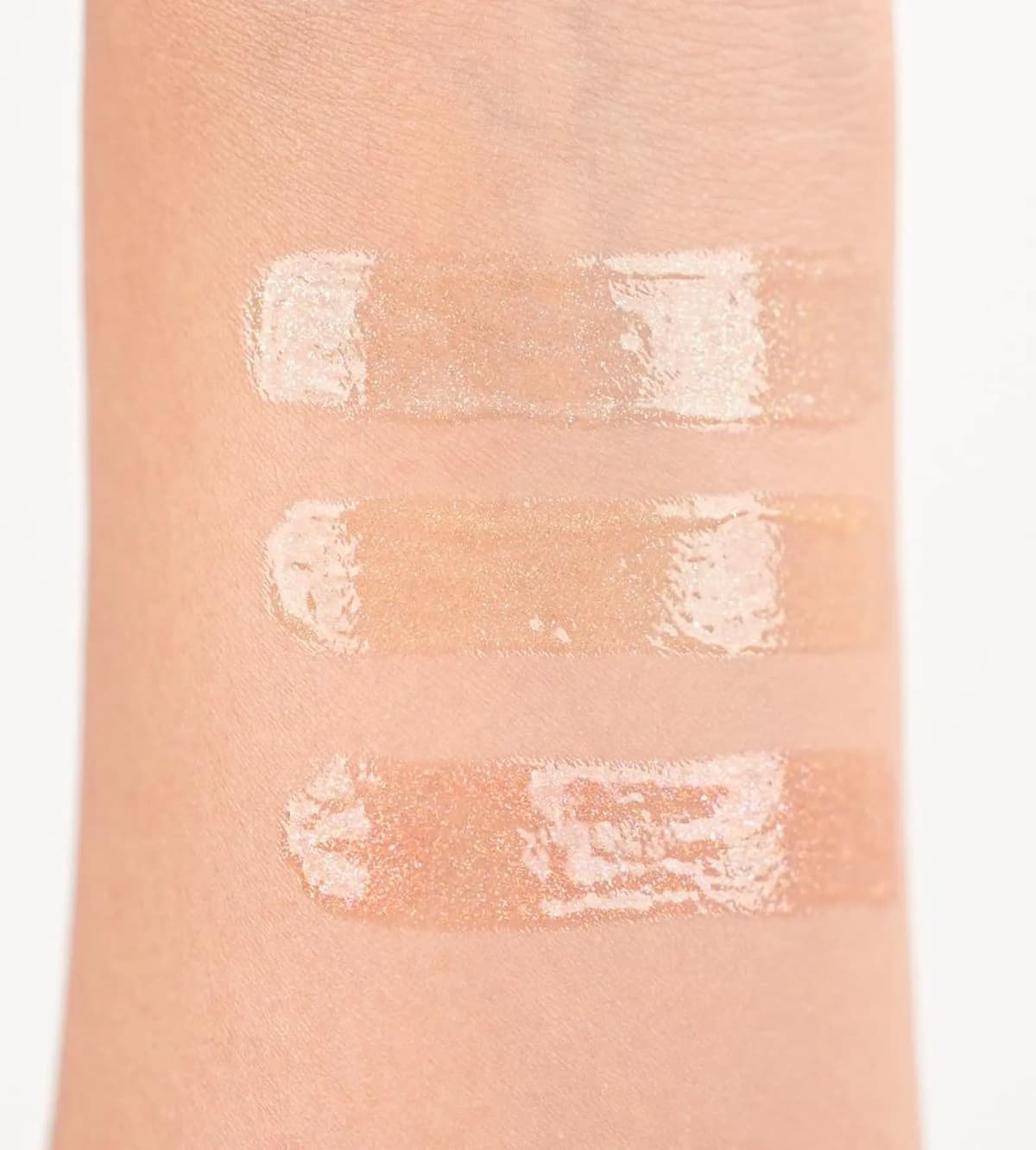 Arm swatches of the three Chanel Holiday 2026 shimmer lip glosses