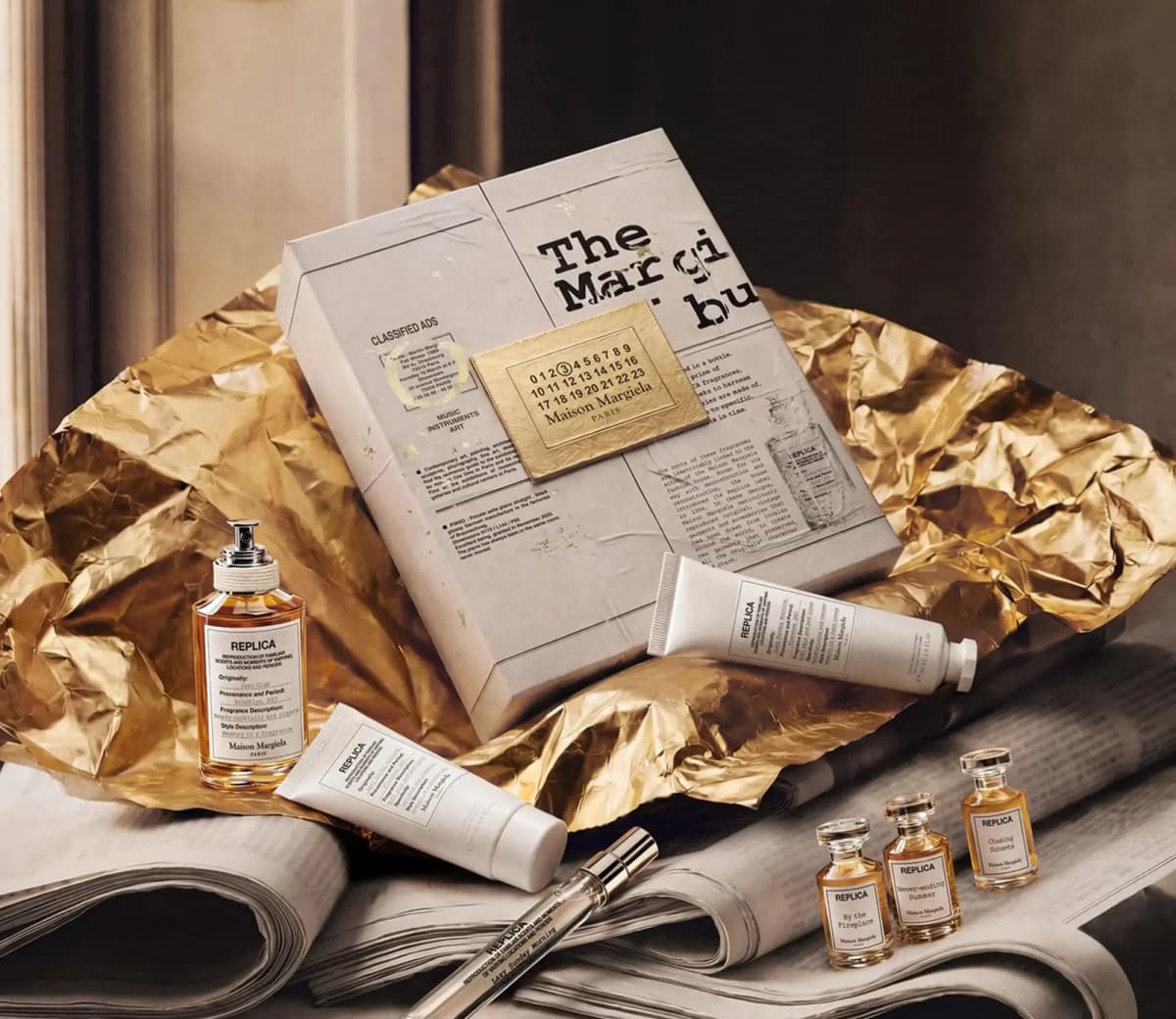 Closed calendar box on crumpled gold foil with Jazz Club, Never-ending Summer, Chasing Sunsets minis and white tubes