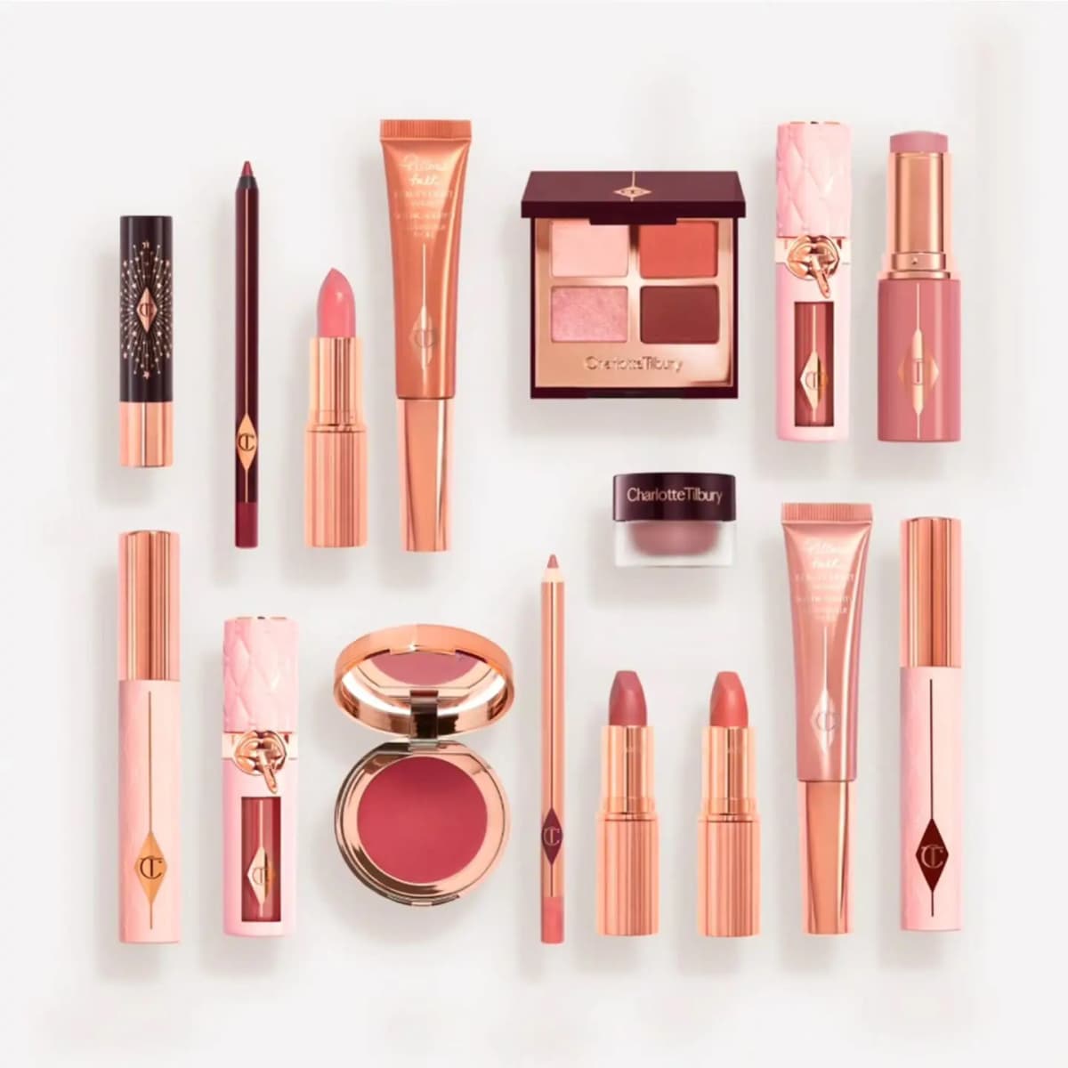 Sixteen Charlotte Tilbury Pillow Talk products in pink and rose-gold packaging arranged in a grid on white, including