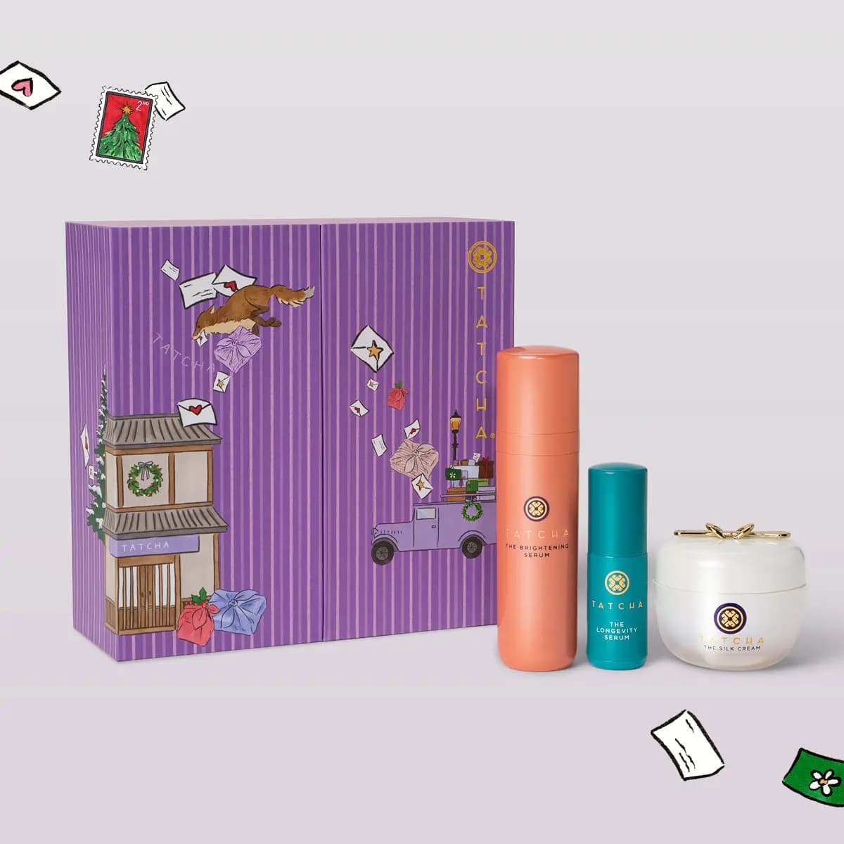 Illustrated purple striped Tatcha box beside The Brightening Serum, The Longevity Serum and The Silk Cream