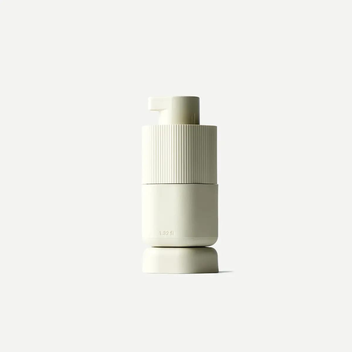 Single Medium cream Pump Capsule marked 1.32 fl on a matching base against white