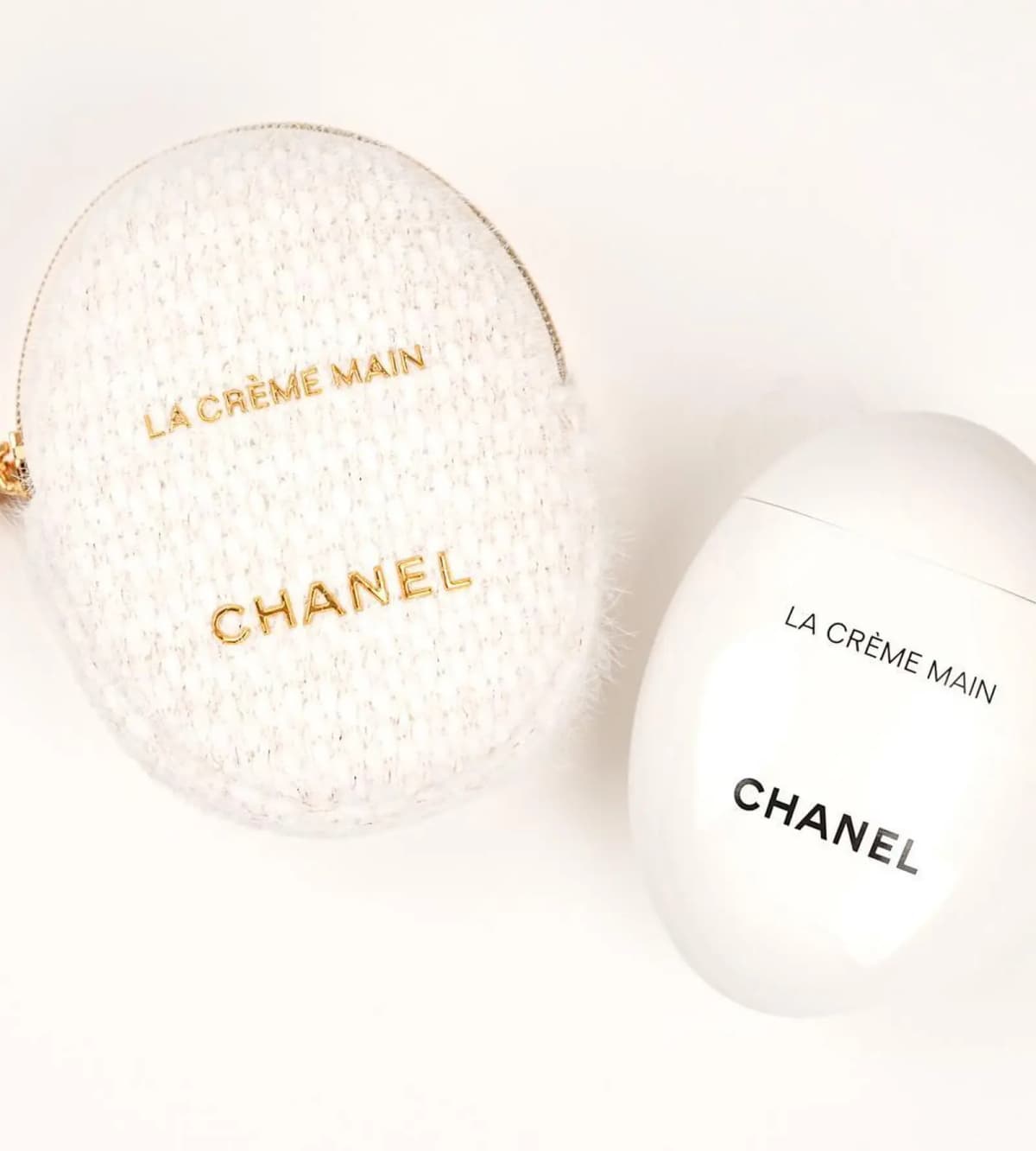 Chanel La Crème Main egg-shaped hand cream beside its tweed pouch for Holiday 2026