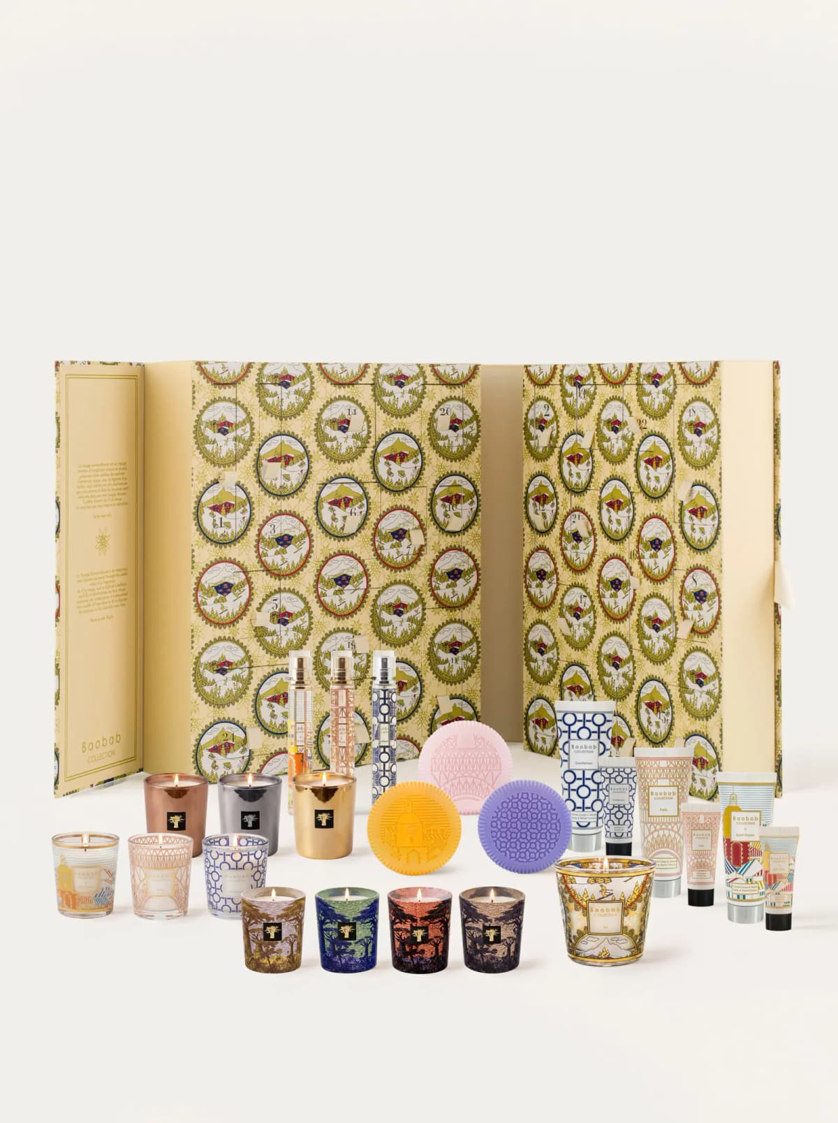Open book-style advent calendar surrounded by its 24 items including mini candles, home sprays, hand creams