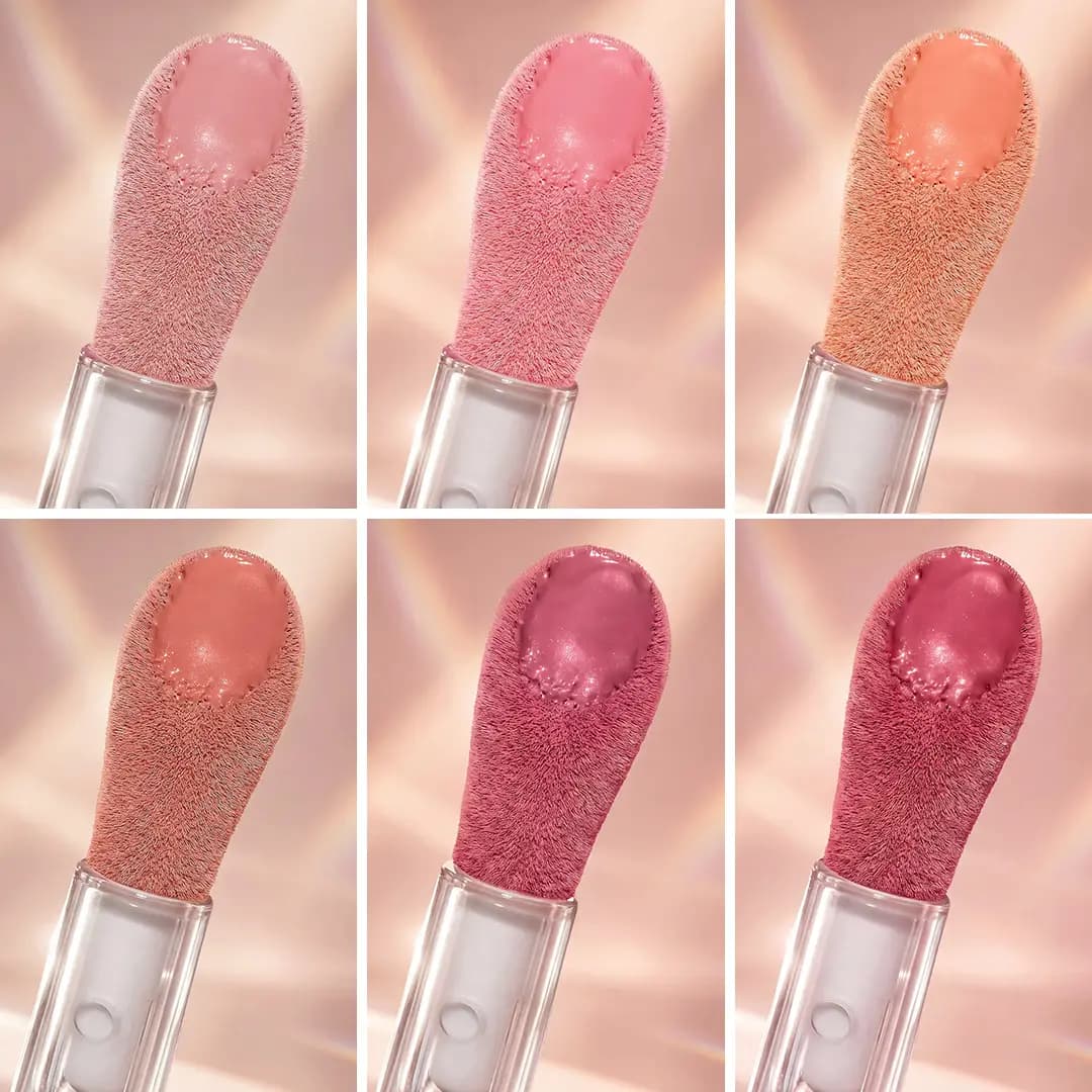 Grid of six fluffy drop-shaped applicators loaded with glossy blush, from soft pink and peach to berry.