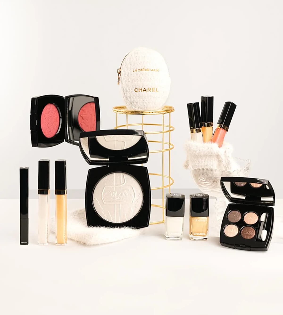 Chanel Holiday 2026 makeup collection group shot with blush, powder, glosses, eyeshadow quad, nail polish and La Crème Main pouch