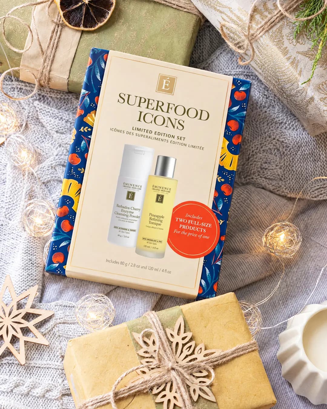 Eminence Superfood Icons Limited Edition Set box on a grey knit blanket with kraft-wrapped gifts and fairy lights