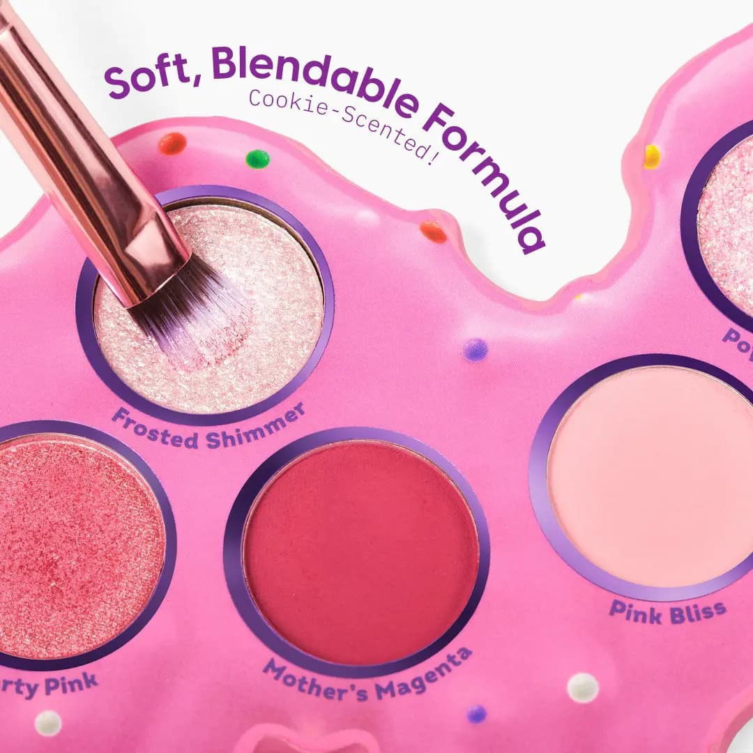 Brush dipped into Frosted Shimmer beside Party Pink, Mother's Magenta and Pink Bliss in the pink camel palette