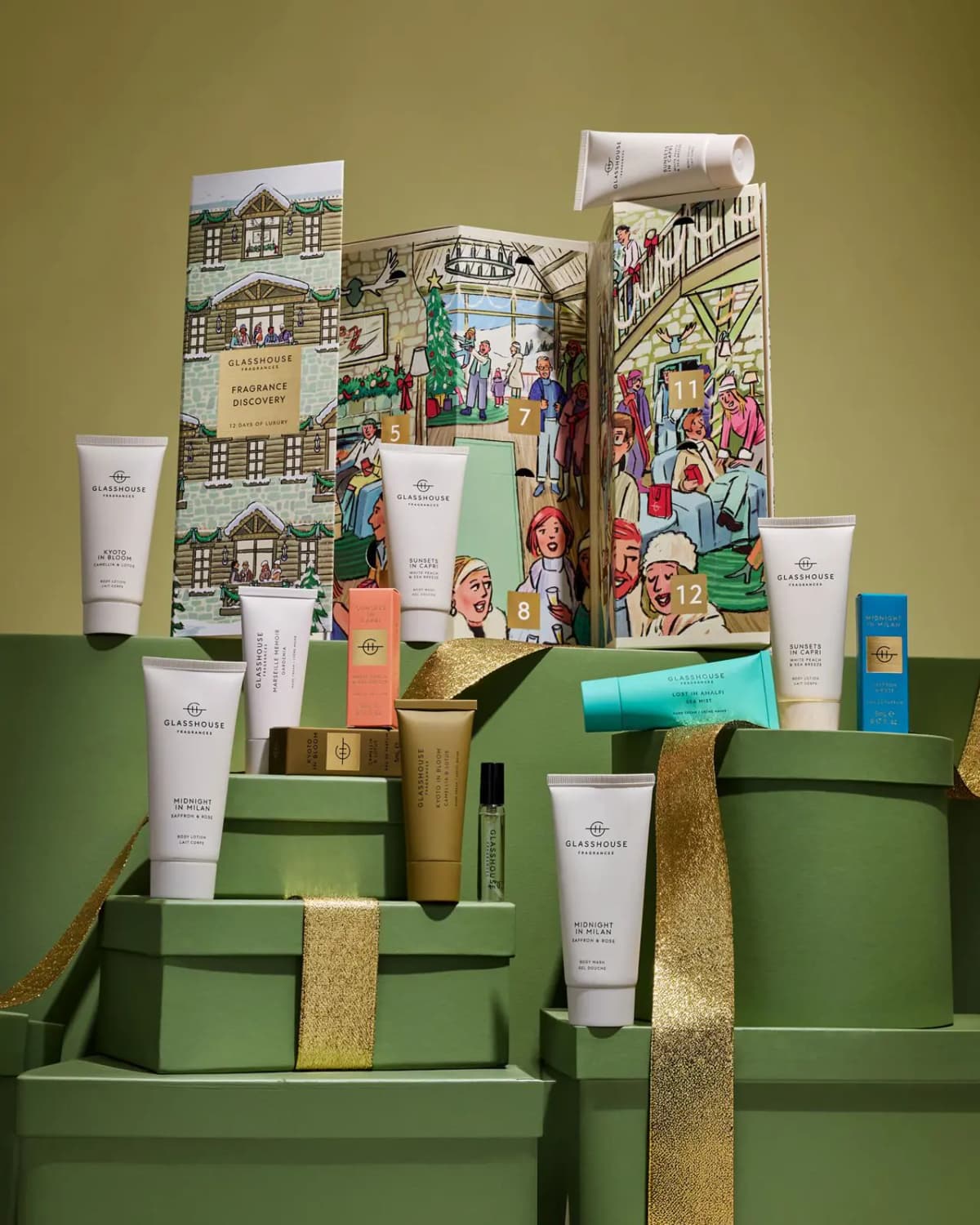Glasshouse Fragrances 12 Days Of Luxury Fragrance Discovery chalet box with its hand creams, body lotions, body washes and Eau de Parfum bottles on green gift boxes with gold ribbon