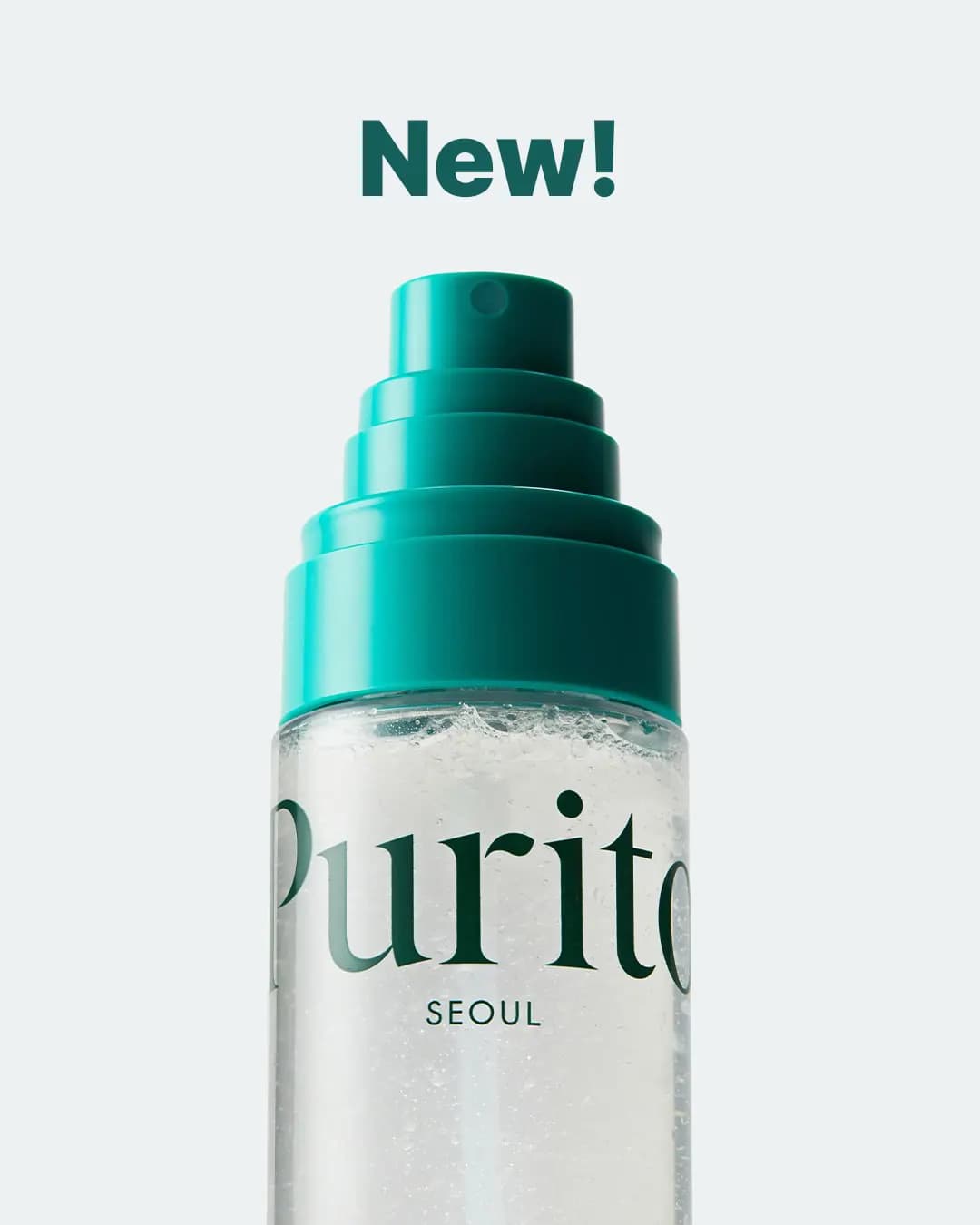 Close-up of a Purito Seoul mist bottle with a tiered teal spray nozzle under a green "New!" headline on pale grey.