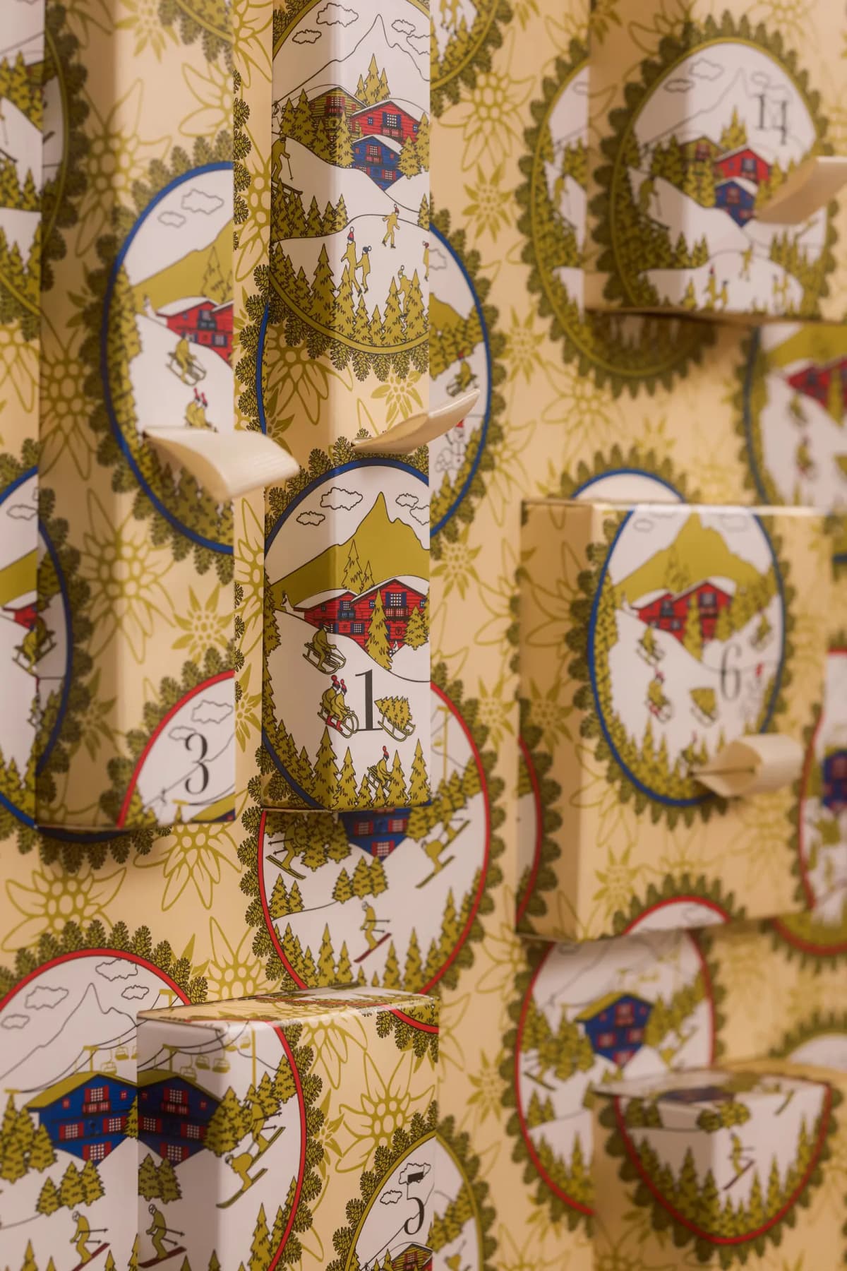 Close-up of the calendar's yellow packaging featuring oval cameos with chalets, skiers and edelweiss motifs