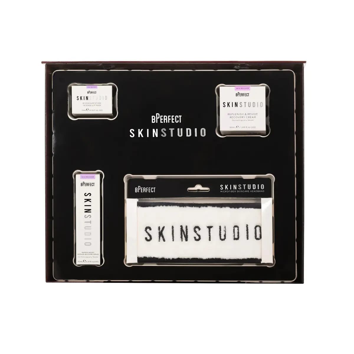 Open black box showing Skin Studio lip mask, recovery cream, recovery serum and white microfiber headband