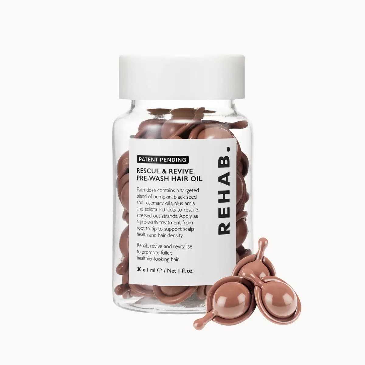 Pre-Wash Hair Oil clear jar of brown single-dose capsules with white lid, three capsules beside it