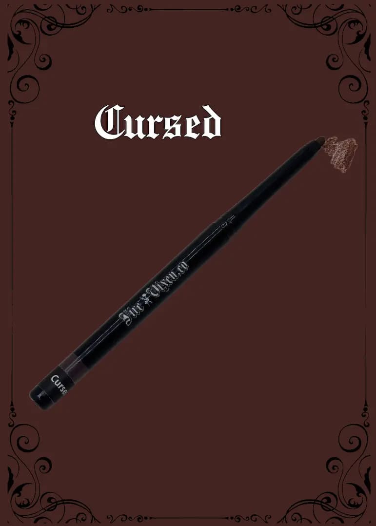 Cursed black retractable lip liner with a medium brown swatch on a chocolate-brown background with gothic scroll frame