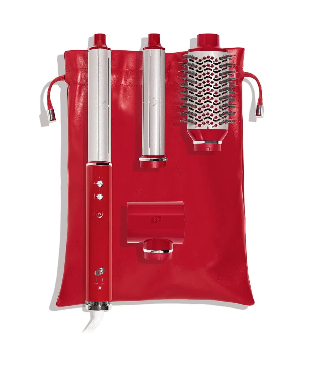 Red base, two silver curling barrels, oval brush and concentrator laid on a red vegan leather drawstring travel tote