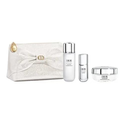 Ivory glitter bow pouch with gold clasp beside Dior Capture essence lotion, serum and youth cream jar