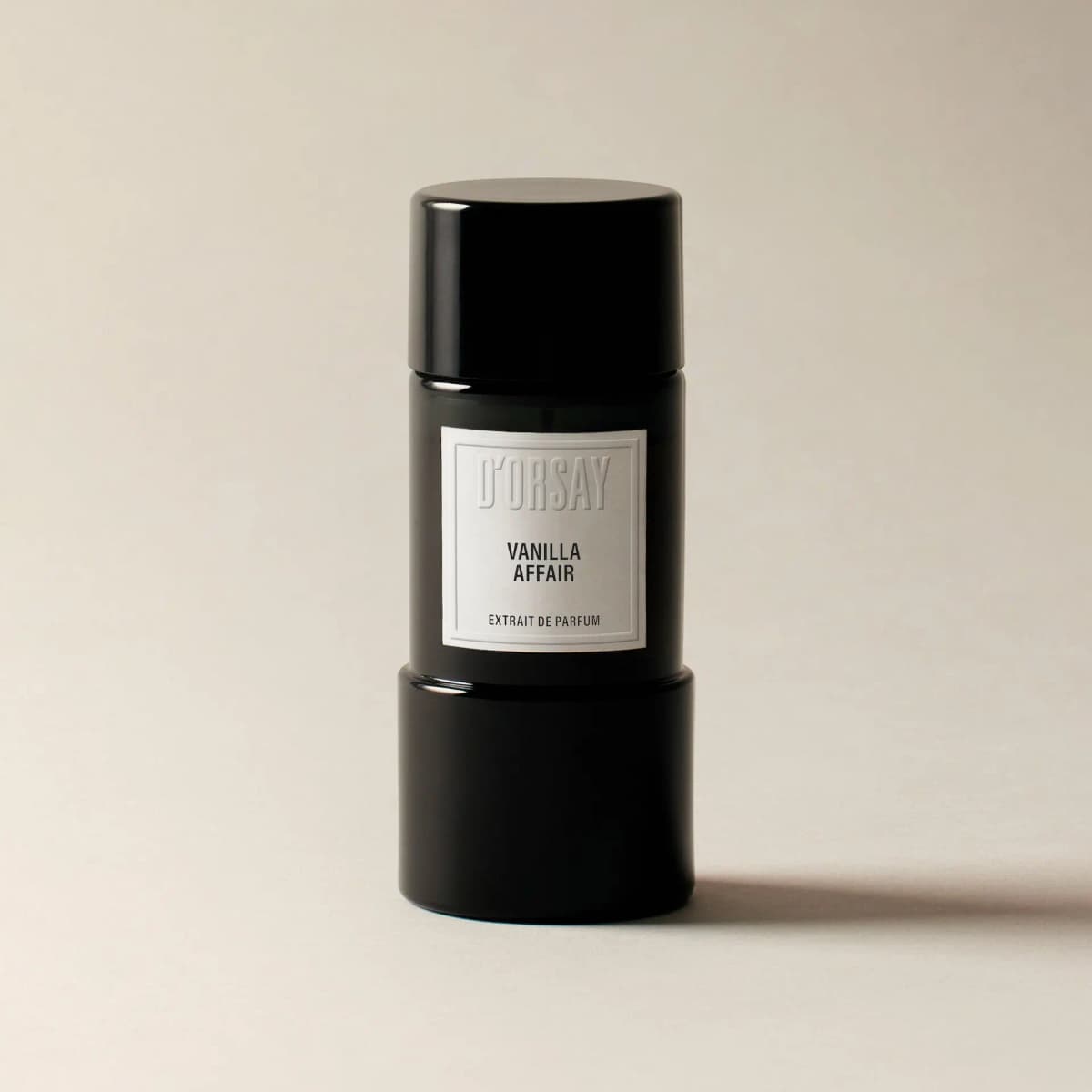 Black cylindrical D'ORSAY Vanilla Affair Extrait de Parfum bottle with white embossed label on a cream background