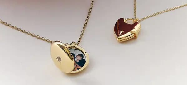 Two gold lockets on fine chains, one oval with a child's photo inside and one heart-shaped
