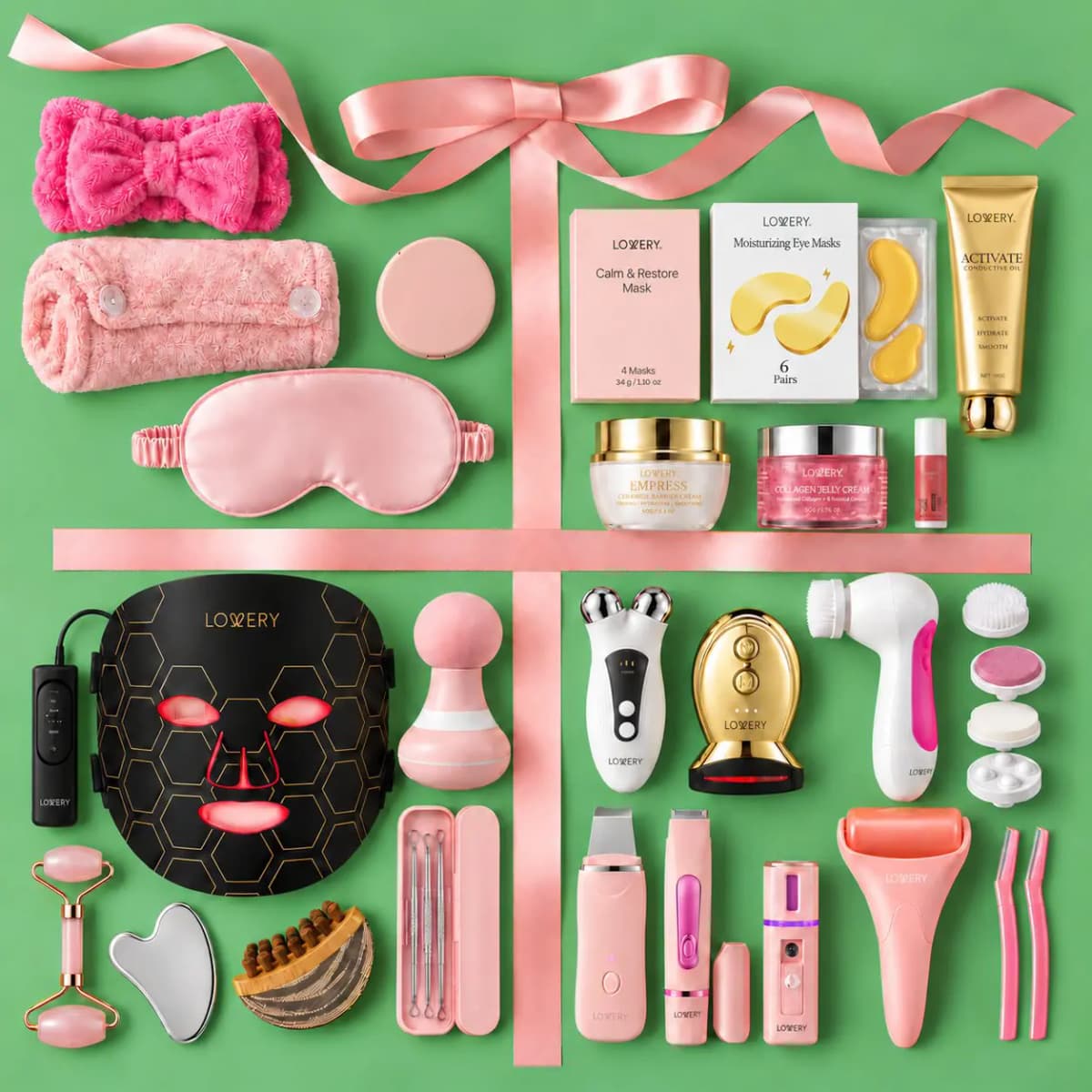 Flat lay of all 24 Lovery items on green, divided by pink satin ribbon into devices, skincare and accessories