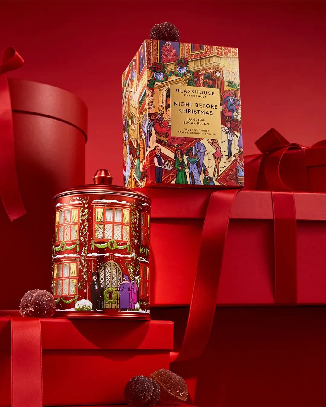 Glasshouse Night Before Christmas red townhouse candle tin and ornate box among red gift boxes and sugared fruit jellies