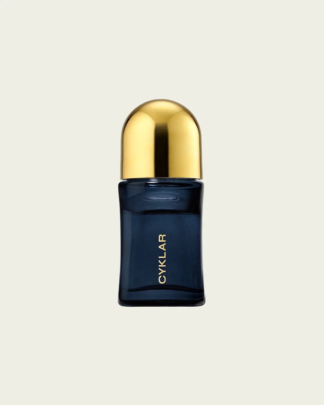 Navy glass deodorant roll-on with a domed gold cap and vertical gold CYKLAR logo on cream