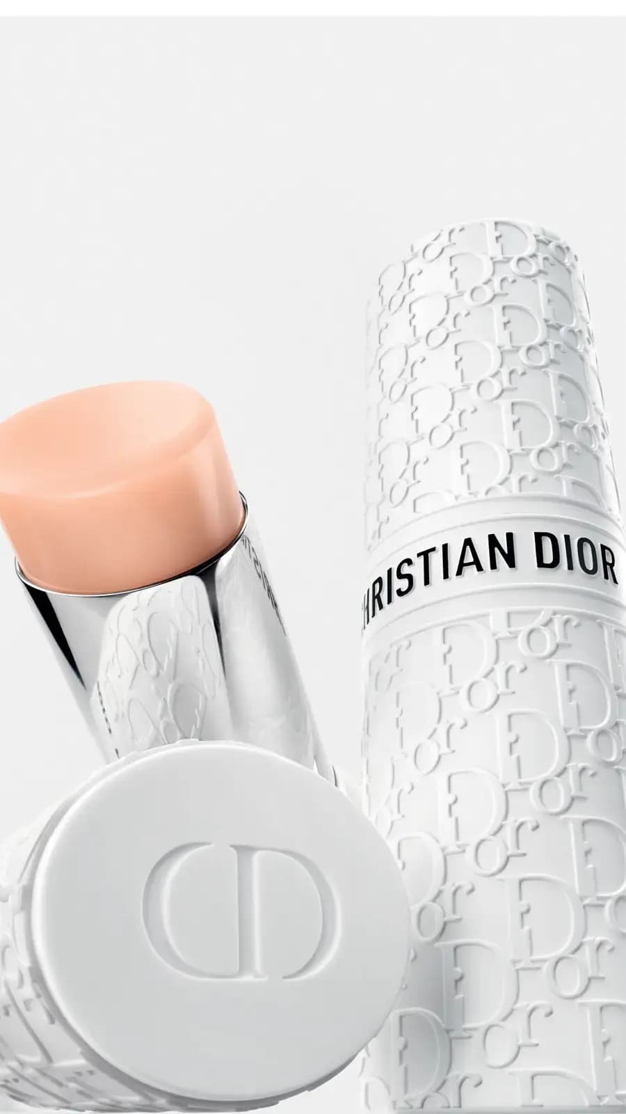 Peach stick angled beside a white Christian Dior case covered in embossed Dior Oblique lettering