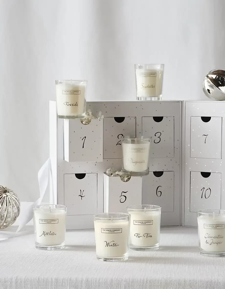 Close-up of white numbered drawers with Fireside, Seychelles, Pomegranate, Mistletoe, Winter and Fir Tree votives