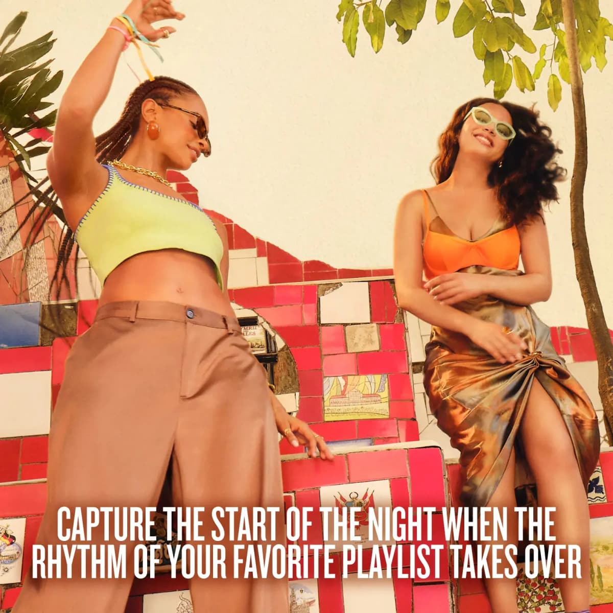 Two women in sunglasses dancing on red mosaic-tiled steps, with text about capturing the start of the night