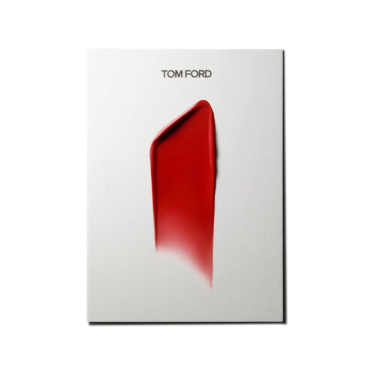 Bright red creamy lipstick smear on a white card printed with the Tom Ford logo