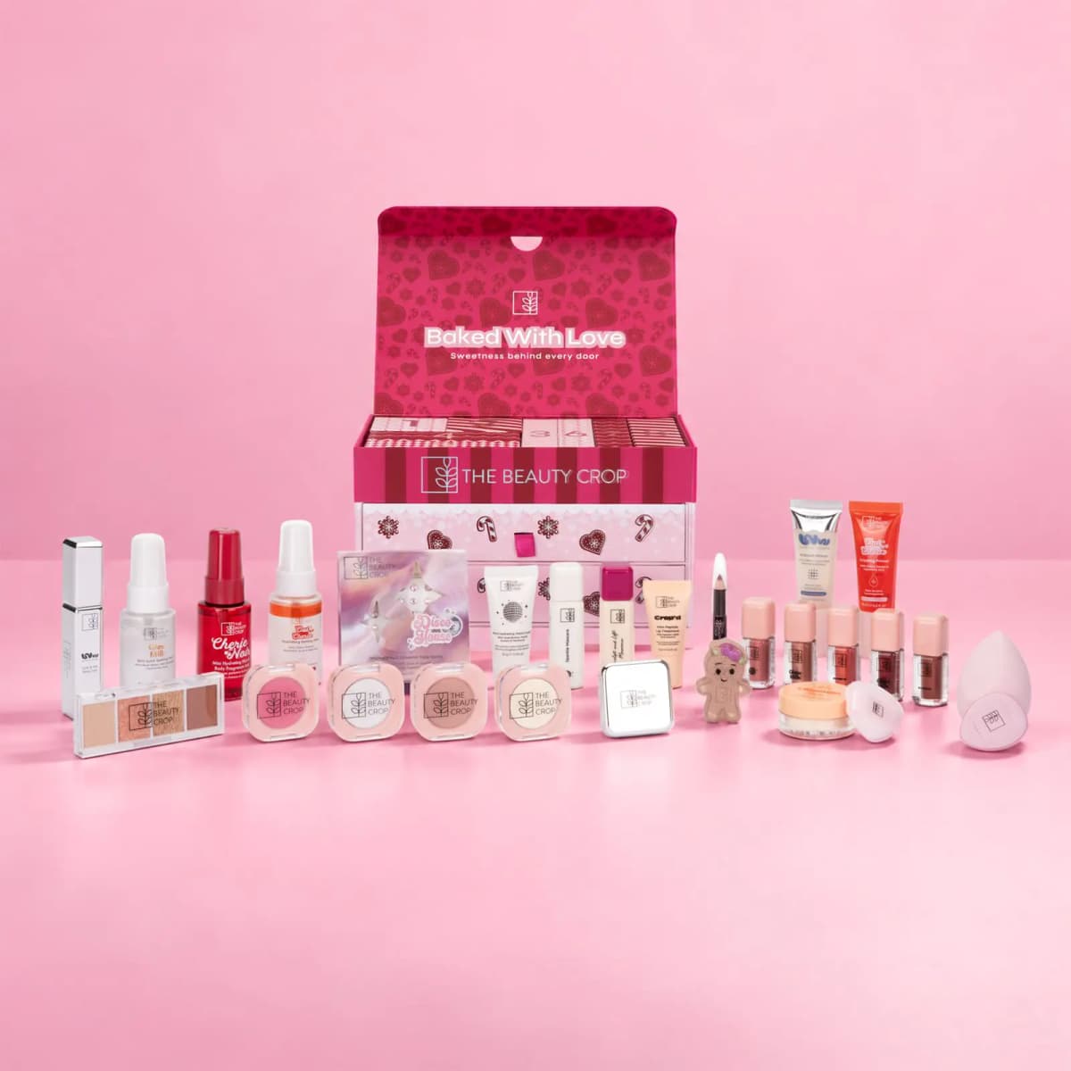 The Beauty Crop Bake House advent calendar with all its makeup minis, mists, blushes and a sponge laid out in front.