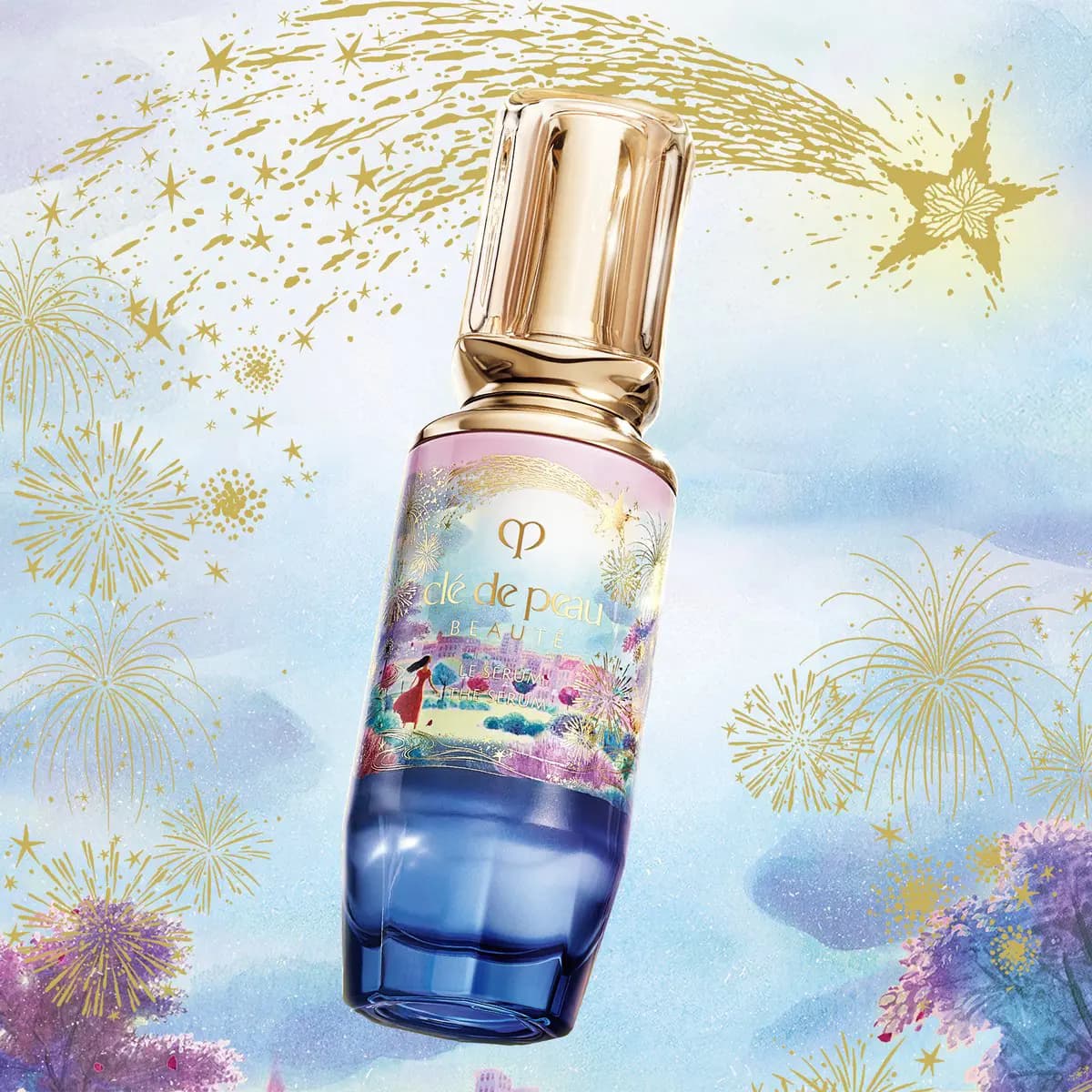 Clé de Peau Beauté The Serum bottle with blue base and a woman in red on the label, surrounded by gold fireworks
