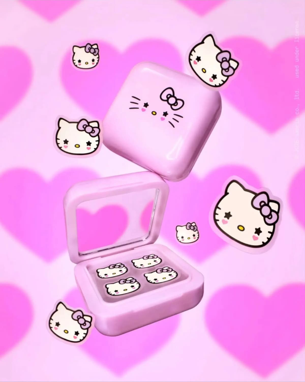 Open lilac compact holding bow Hello Kitty patches with mirror, surrounded by stickers on a pink heart backdrop