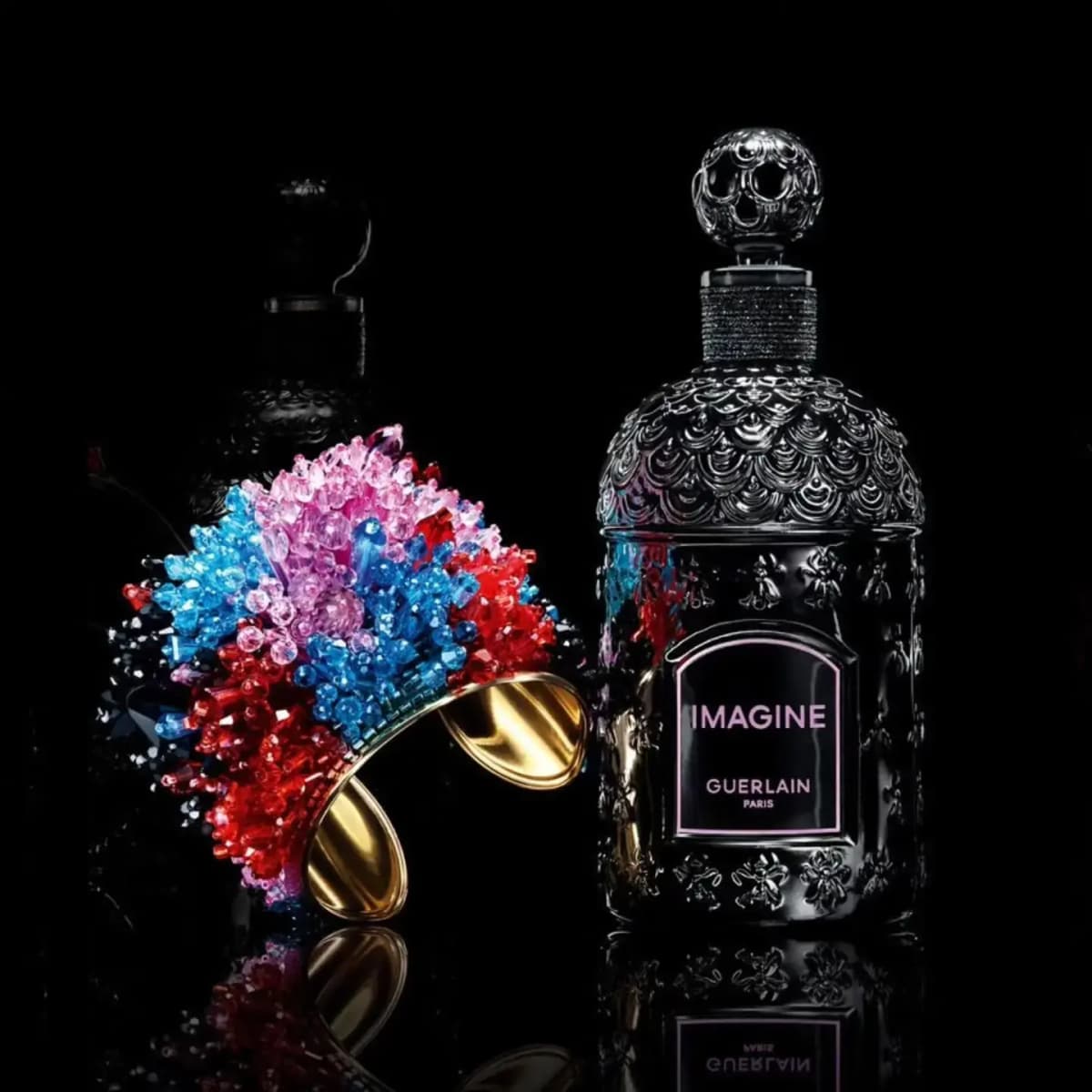 Gold-lined beaded cuff removed and shown beside the black bottle with its pink-lettered Imagine Guerlain Paris label