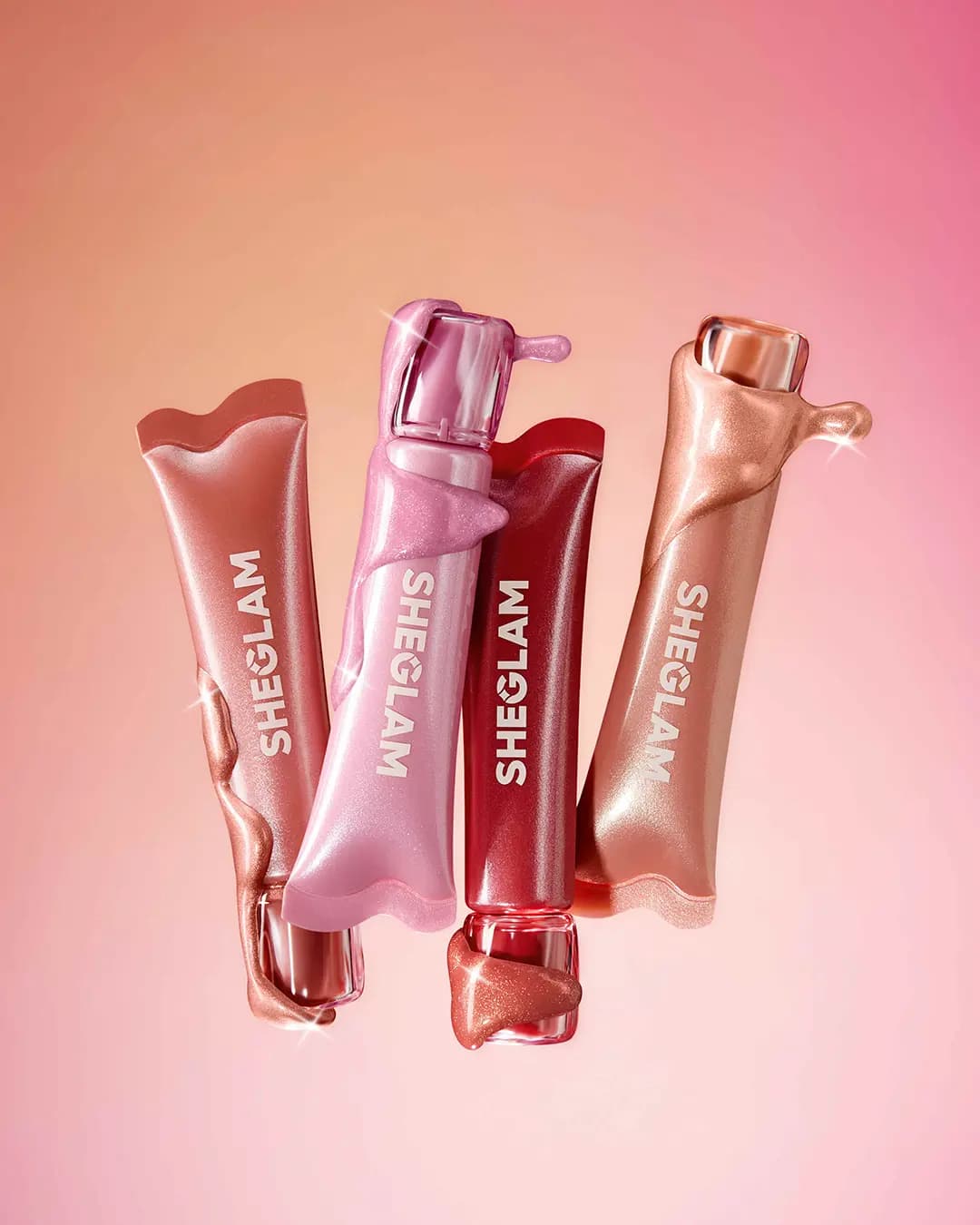 Four shimmer blush tubes in rose, pink, red and peach draped in dripping glittery formula on a peach-pink gradient