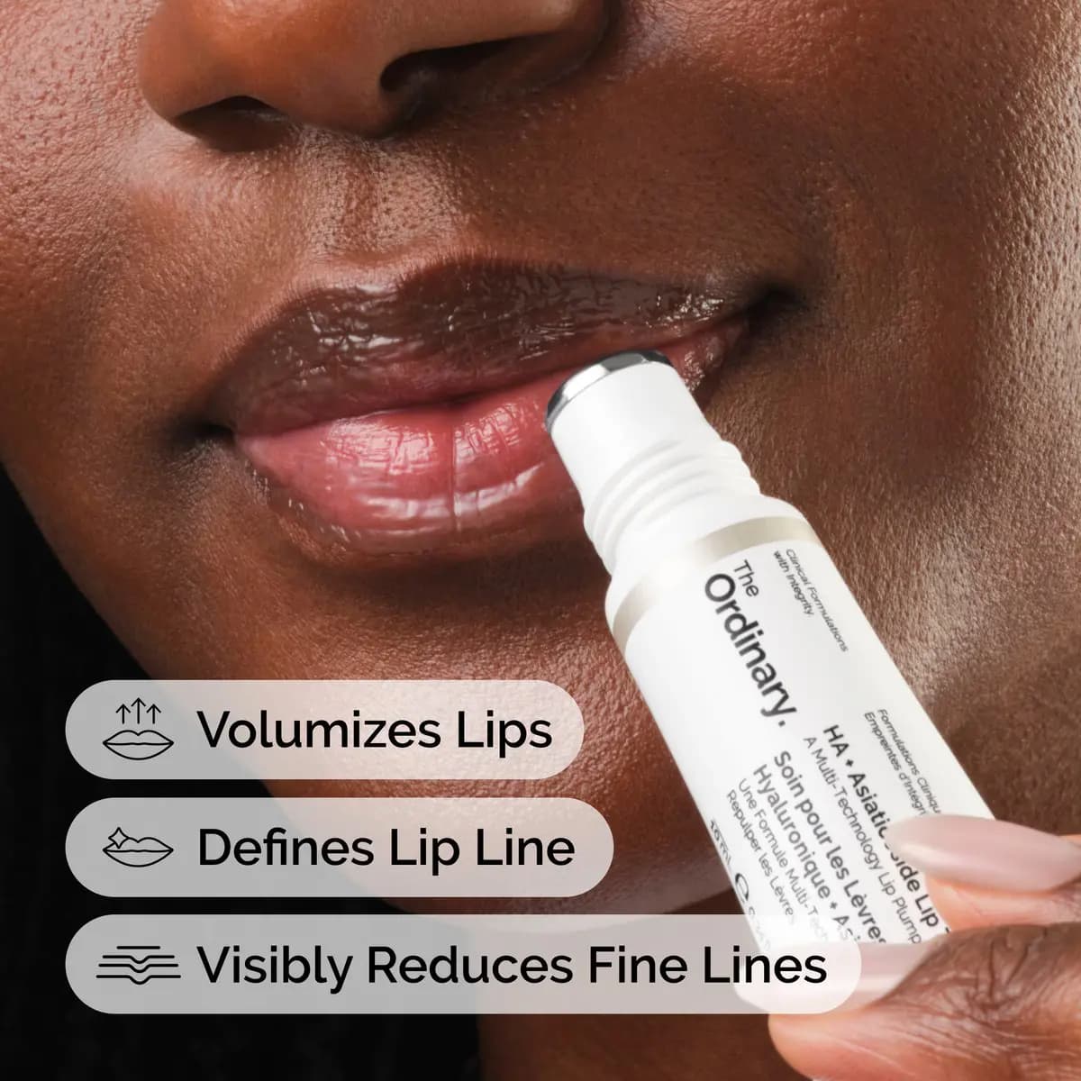 Model applying the metal-tipped tube to glossy lips, with icons for volumizing, lip line and fine-line claims