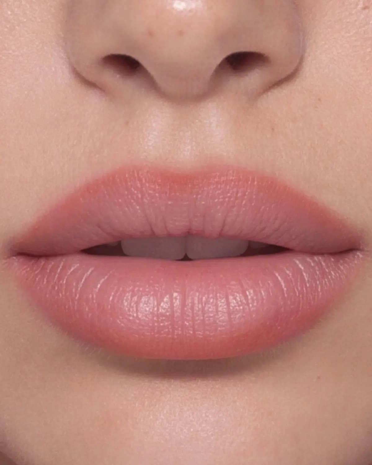 Close-up of fair-skinned lips lined and filled with a soft, blurred peachy-pink colour
