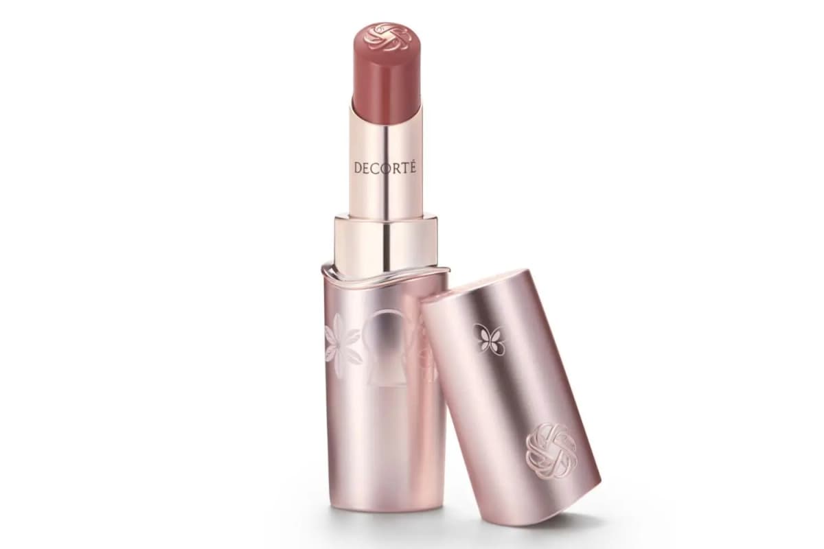 Rouge Decorté Cream Glow lipstick in a muted rosy brown with rose-gold keyhole-engraved case and cap