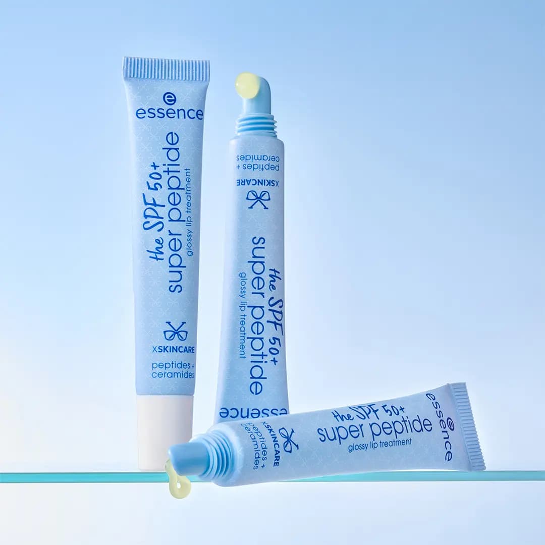 Three blue SPF 50+ super peptide tubes on a glass shelf, two uncapped showing pale yellow gloss