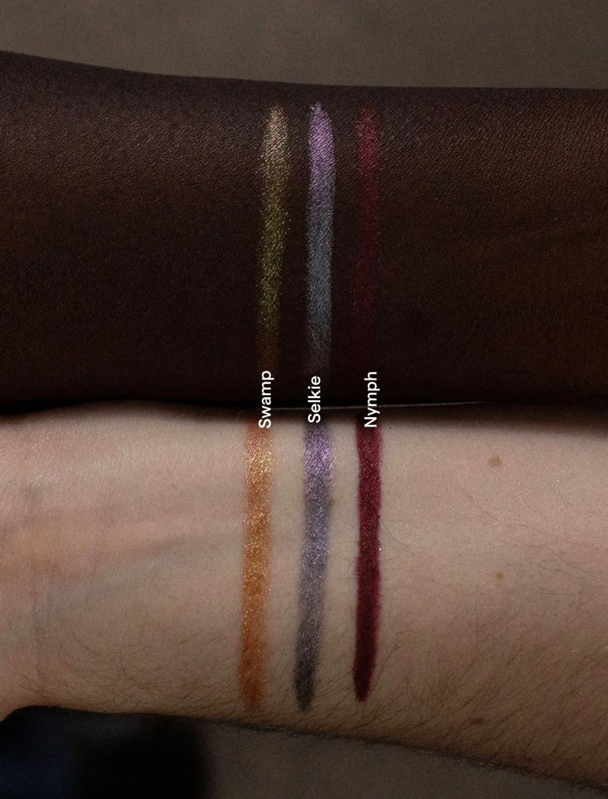 Swamp, Selkie and Nymph pencil swatches in gold-green, violet-grey and berry on deep and light forearms