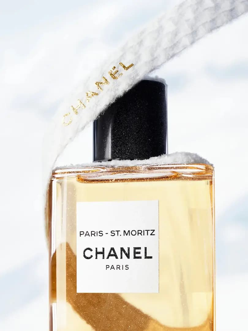 CHANEL Paris – St. Moritz bottle with black cap, draped in a fluffy white knit band with gold CHANEL lettering