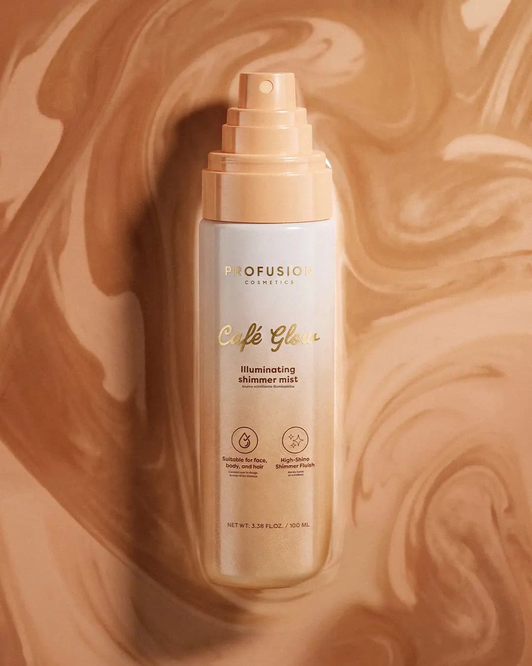 Café Glow illuminating shimmer mist bottle laid flat on a swirl of caramel and cream tones.
