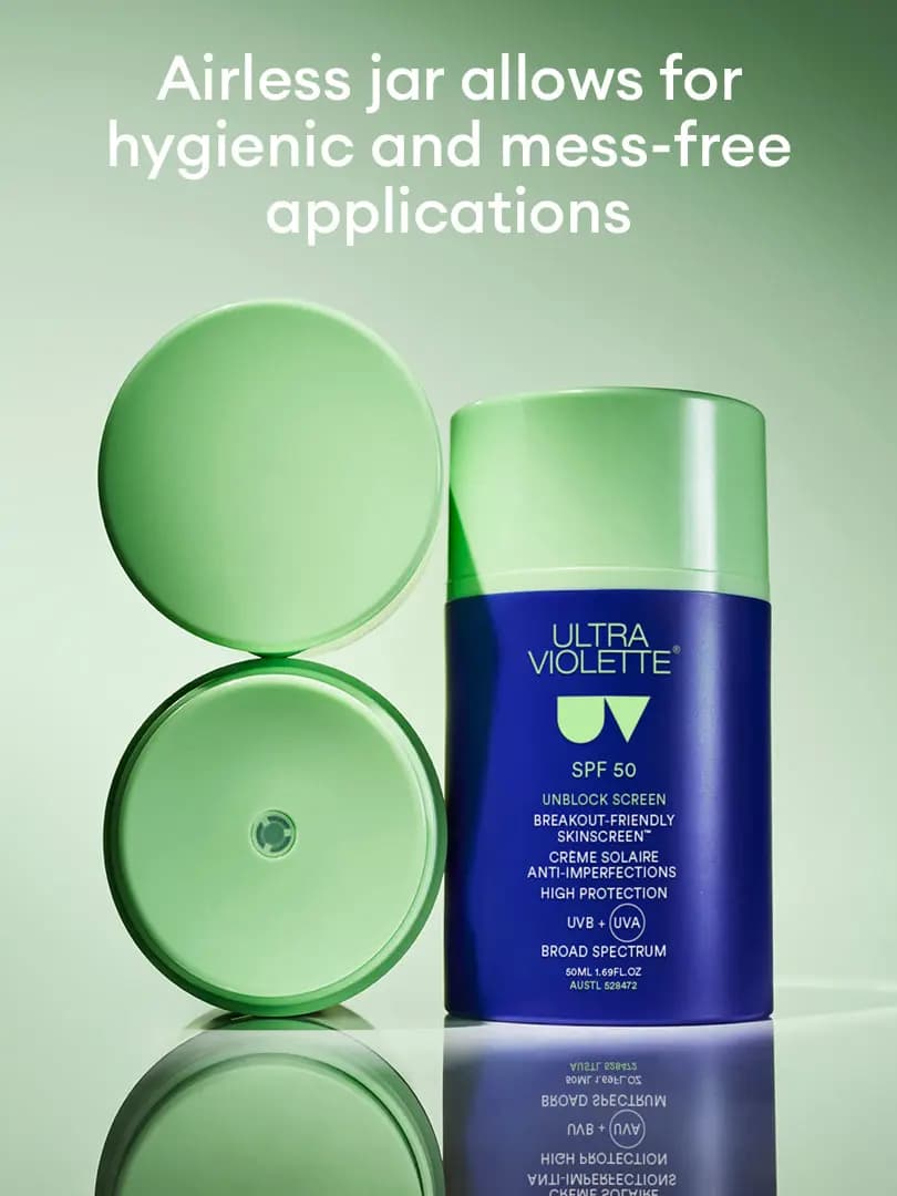 Open airless jar with mint-green lid and pump disc beside the blue Unblock Screen SPF 50 jar on a green reflective surface