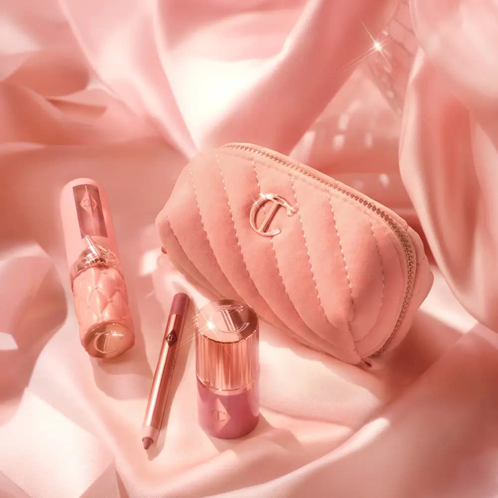 Quilted pink velvet bag, gloss with quilted cap, lip liner and rose gold blush stick on draped pink satin